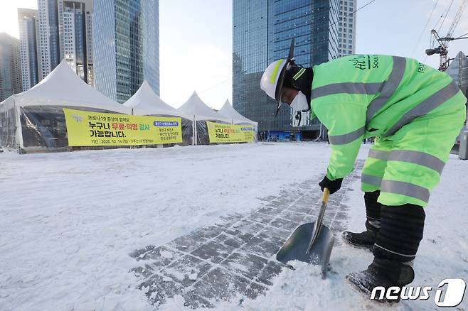 7일 오전 서울 서울 용산역 앞 코로나19 임시선별검사소 앞에서 환경미화원이 제설작업을 하고 있다. 2021.1.7/뉴스1 © News1 임세영 기자