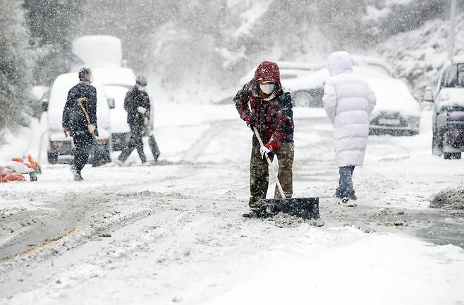 광주·전남에 대설·한파 특보가 내려진 7일 오전 광주 북구 운암3동 한 도로에서 광주 북구청과 동행정복지센터 공무원들이 도로에 쌓인 눈을 치우고 있다./광주 북구 제공