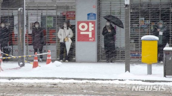 광주와 전남 일부지역에 대설특보가 내려진 7일 오전 광주 동구 금남로 길가에서 시민들이 버스를 기다리고 있다. 뉴시스 제공