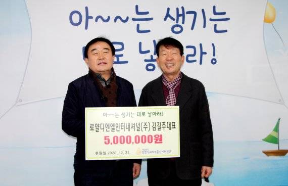 김길주 로얄디엔엘인터내셔널(주) 대표이사(왼쪽)가 출산축하금 500만원을 기부하면서 김영식세자녀출산지원재단 이사장과 기념촬영을 하고 있다. 김영식세자녀출산지원재단 제공