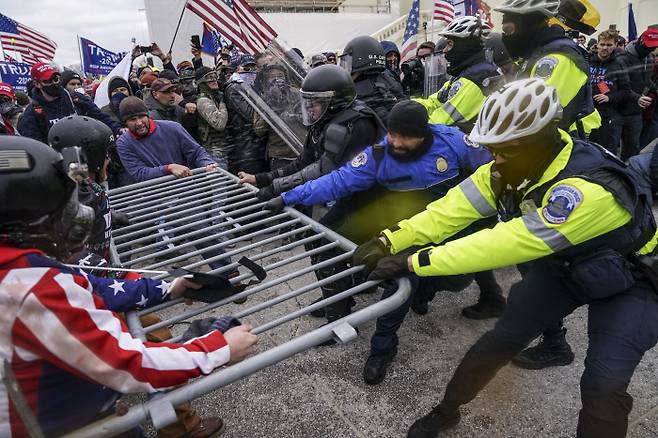 친 트럼프 시위대가 6일(현지시간) 미국 워싱턴 연방의회 앞으로 몰려가 펜스를 무너뜨리며 경찰과 충돌하고 있다. 워싱턴|AP연합뉴스