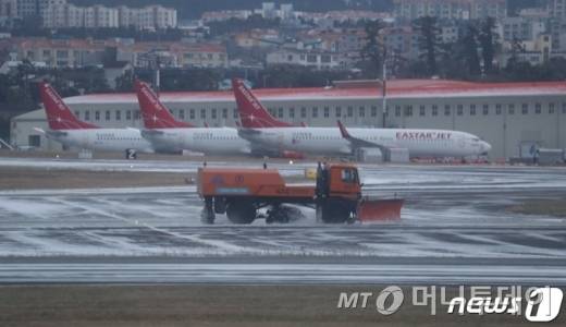 (제주=뉴스1) 오현지 기자 = 7일 오전 제주국제공항 활주로에서 제설 작업이 진행되고 있다.  이날 오전 6시30분 기준 현재 제주도 산지에는 대설·한파경보, 나머지 지역에는 대설주의보가 발효 중이다.2021.1.7/뉴스1  <저작권자 ⓒ 뉴스1코리아, 무단전재 및 재배포 금지>