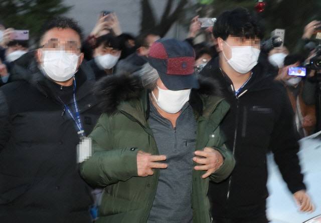 출소한 아동 성범죄자 조두순이 12일 오전 경기도 안산시 법무부 안산준법지원센터로 들어가고 있다. 사진에서 조두순은 오른손에 감귤 한 개를 쥐고 있었고 옷을 고쳐입는 과정에서 손가락이 ‘브이’ 모양으로 포착돼 논란이 일고 있다./연합뉴스