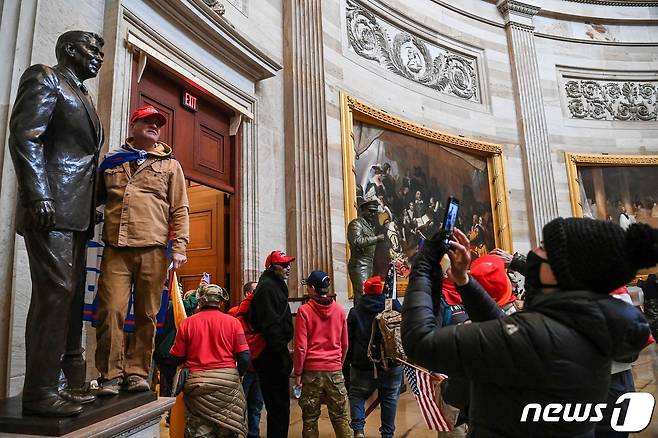 6일(현지시간) 워싱턴 의사당에 난입한 도널드 트럼프 미국 대통령을 지지하는 시위대가 기념촬영을 하고 있다. © AFP=뉴스1 © News1 우동명 기자