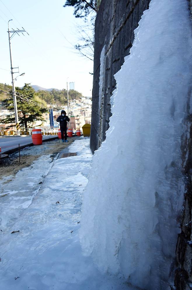 북극발 한파가 전국을 덮친 지난 7일 부산 동구 한 마을 옹벽에 큰 고드름이 생겨 눈길을 끌고 있다. 부산은 8일 오전 영하 12.2도를 기록하며 올 겨울 가장 추운 날씨를 보였다. /뉴시스