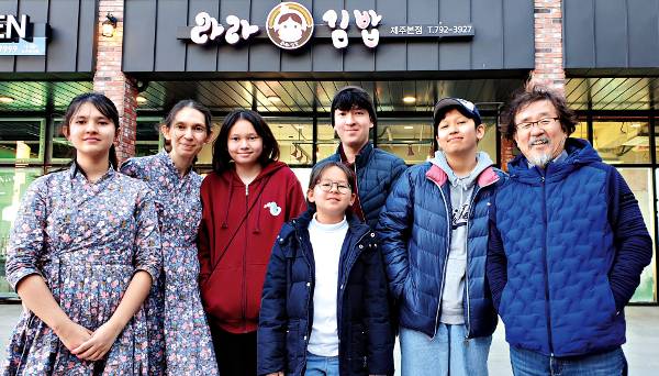 제주도에서 김밥집을 운영하는 김다윗 목사가 지난달 서귀포 안덕면 가게 앞에서 가족들과 함께했다. 왼쪽부터 마리아, 다리아 사모, 아도니아, 라라, 다윗, 에클레시아, 김 목사.