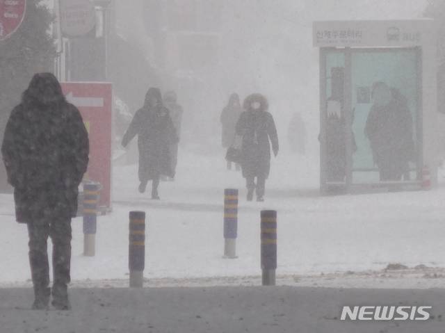 [제주=뉴시스]강경태 기자 = 제주도 전역에 대설특보가 내려진  8일 오전 제주시 연동 신제주로터리 인근 도로에서 시민들이 발걸음을 재촉하고 있다. 2021.01.08. ktk2807@newsis.com