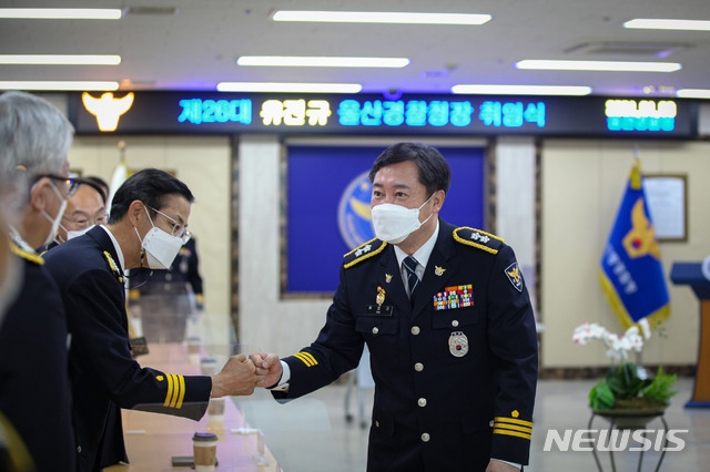 [울산=뉴시스]8일 취임한 유진규 신임 울산경찰청장이 간부 직원들과 주먹인사를 하고 있다. (사진=울산경찰청 제공) 2021.01.08. photo@newsis.com