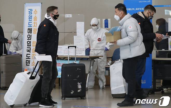 8일 오후 인천국제공항 제2여객터미널에서 방역 관계자들이 해외 입국자들에게 동선을 안내하고 있다. 방역당국은 신종 코로나바이러스 감염증(코로나19) 변이 바이러스의 국내 유입을 막기 위해 이날부터 모든 외국인 입국자에 대해 PCR(유전자 검사법) 음성확인서 제출을 의무화했다. 공항은 8일부터, 항만은 15일부터 시행된다. 2021.1.8/뉴스1 © News1 임세영 기자