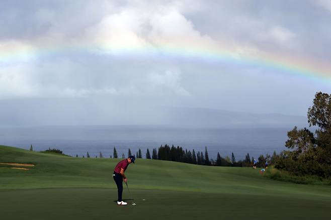 PGA 투어 센트리 토너먼트 오브 챔피언스 1라운드가 열린 8일 하와이 카팔루아 리조트 플랜테이션 코스 4번홀 그린 위로 무지개가 떠 있다. 퍼트하는 선수는 브라이언 게이./AFP 연합뉴스