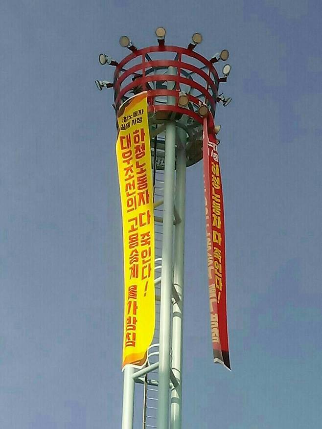 ‘고용승계’ 펼침막이 보이는 대우조선소 조명탑에서 사내협력사 노동자 강병재씨가 농성 중이다. 그는 농성 203일째인 지난 6일 내려와 병원으로 이송됐다. 금속노조 제공