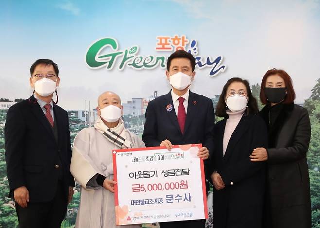 ▲ 문수사 주지 덕화 스님과 신행단체 대표들이 이강덕 시장에게 성금을 전달한 뒤 기념촬영을 하고 있다. 포항시 제공