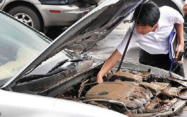 정비업계 관계자가 침수 상태를 살펴보고 있다. [사진 출처 = 매경DB]