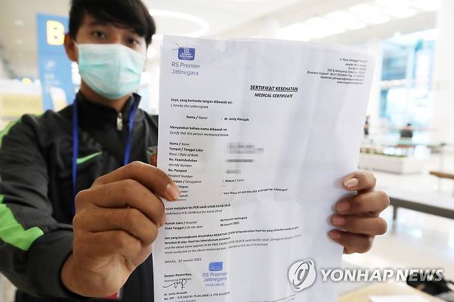 'PCR 음성확인서 내고 입국했어요' (영종도=연합뉴스) 김도훈 기자 = 전국 공항을 통해 입국하는 외국인들에 대한 신종 코로나바이러스 감염증(코로나19) 유전자증폭(PCR) 검사 음성 확인서 제출 의무화 조치가 시행된 8일 인천국제공항 제2터미널에서 한 인도네시아 입국객이 확인서를 보여주고 있다. 2021.1.8 superdoo82@yna.co.kr