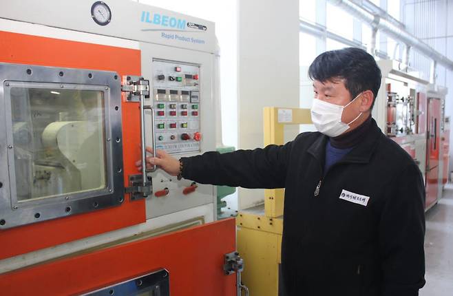 강 대표가 플라스틱 사출기를 살펴보는 모습.