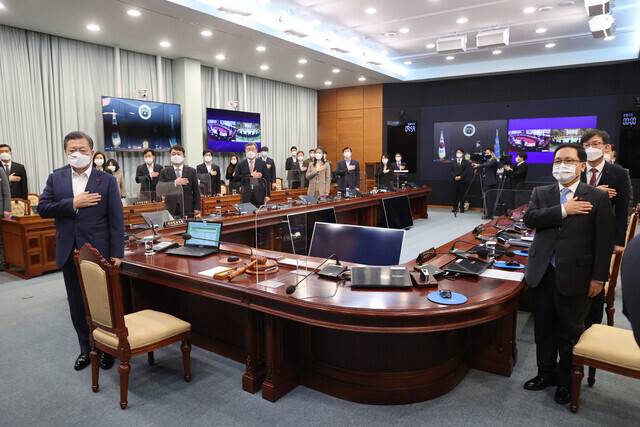 South Korean President Moon Jae-in and senior Blue House secretaries and aides pledge allegiance to the flag during the first Cabinet meeting of 2021. (photo pool)