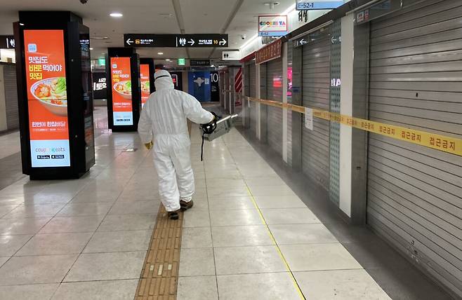9일 오후 서울 강남역 지하도상가에서 서울시설공단 관계자가 코로나19 확진자 발생으로 폐쇄된 상가 일대를 소독하고 있다. 연합뉴스