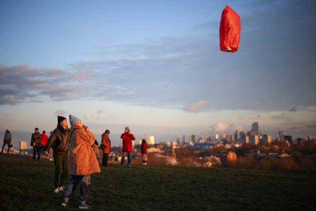 영국인들이 6일 영국 런던 프림로즈힐공원에서 풍등을 날리고 있다. 런던=로이터 연합뉴스