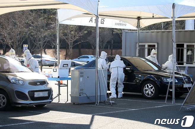 10일 오전 대구 수성구 대구스타디움 제3주차장에 마련된 차량 탑승(드라이브스루) 방식의 신종 코로나바이러스 감염증(코로나19) 임시선별검사소에서 코로나19 진단검사에 투입된 민간의료기관 의료진이 검체를 채취하고 있다.  사진은 기사와 직접적 관련 없음. 2021.1.10/뉴스1 © News1 공정식 기자