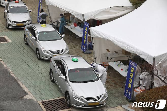 11일 오후 부산 연제구 부산아시아드주경기장 주차장에서 택시 기사들이 드라이브 스루로 신종 코로나바이러스 감염증(코로나19) 검사를 받고 있다. 부산시는 오는 15일까지 지역 내 무증상 감염자 조기 발견을 위해 택시 운수종사자를 대상으로 '찾아가는 이동 선별검사소'를 운영한다. 2021.1.11/뉴스1 © News1 여주연 기자