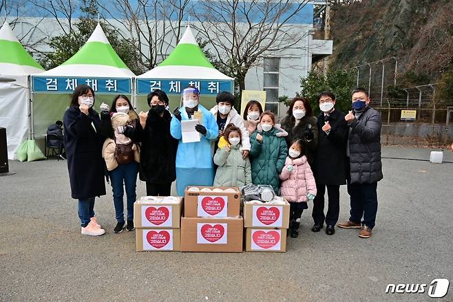 부산 사하구 임시 선별검사소 인근 주민들이 의료진을 위해 핫팩, 손난로 등 성품과 손편지를 전달하고 기념촬영을 하고 있다.(사하구청 제공)© 뉴스1