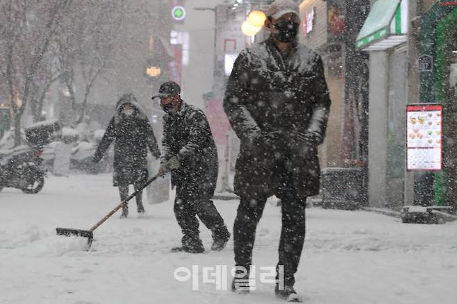 [이데일리 이영훈 기자] 갑작스런 폭설이 내린 12일 오후 서울 중구 명동 일대에서 한 상인이 제설 작업을 펼치고 있다.