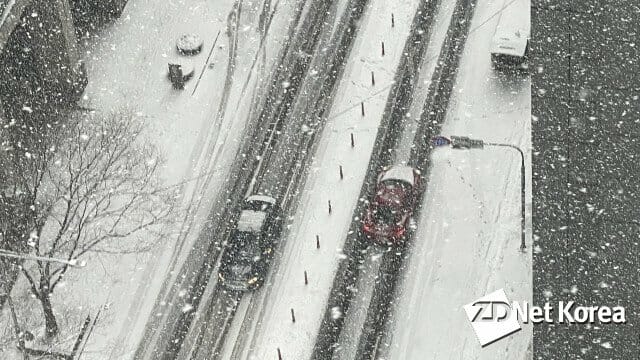 12일 오후 3시 30분부터 서울 시내 최대 4cm 눈이 내리는 대설주의보가 내려진 가운데, 차량들이 눈으로 쌓인 서울 한 이면 도로 위를 주행하고 있다.