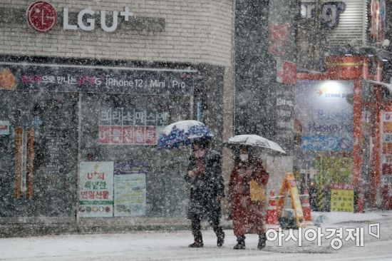 서울 등 수도권과 서해안을 중심으로 함박눈이 내린 12일 서울 신촌 거리에서 시민들이 분주하게 움직이고 있다. /문호남 기자 munonam@