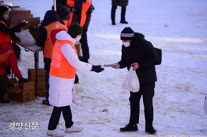 명동밥집의 한 관계자가 지난 8일 옛 계성여중고 운동장에서 노숙인에게 도시락 나눔을 하고 있다. 서울대교구 제공