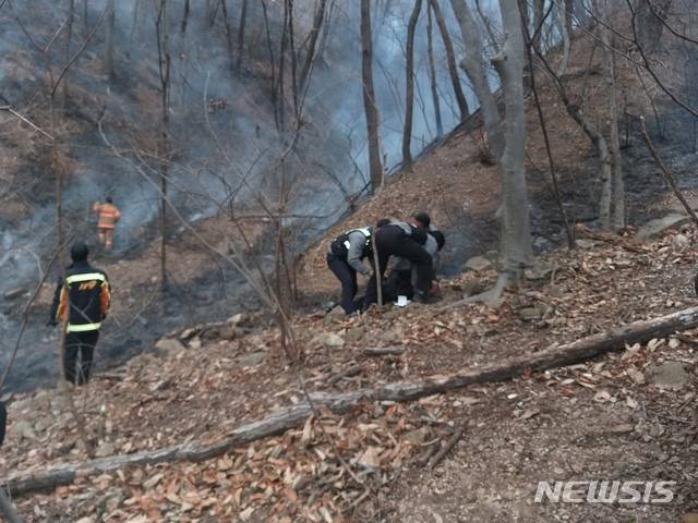 [경주=뉴시스] 이은희 기자= 경주경찰이 11일 무장산 화재현장에서 방화범으로 추정되는 60대 남성을 붙잡고 있다. (사진= 경주소방서 제공) 2021.1.12. photo@newsis.com