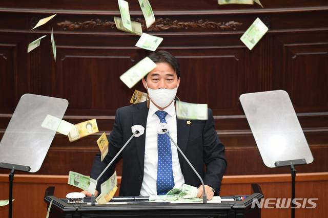 [창원=뉴시스] 홍정명 기자=12일 오후 열린 경남도의회 제382회 임시회 1차 본회의에서 송순호 도의원이 신상발언 도중 현금 200만 원을 뿌리고 있다.(사진=송순호 의원 제공) 2021.01.12. photo@newsis.com