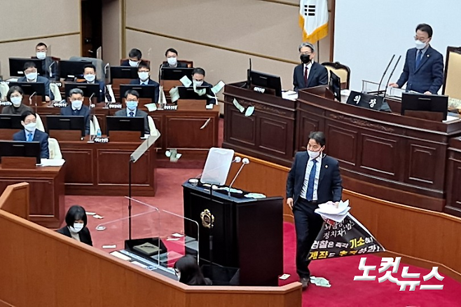 송순호 경남도의원이 12일 본회의 신상발언에서 지폐를 뿌리고 있다. 송봉준 기자