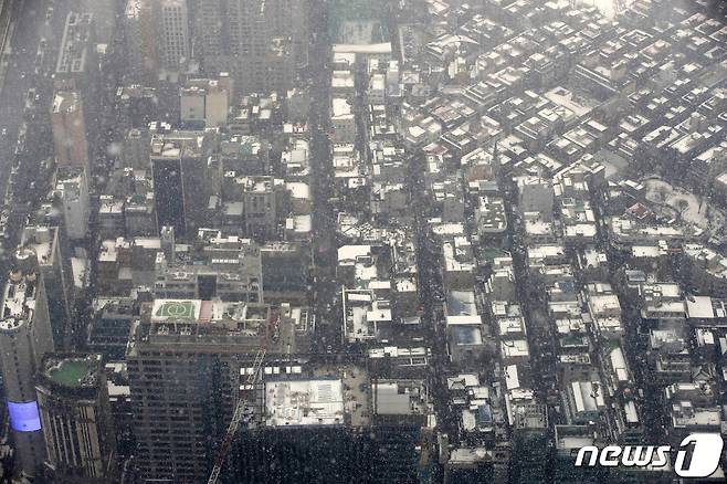 서울 동남·서남권, 경기도 광명·시흥에 대설주의보가 발효된 12일 오후 서울 송파구 롯데월드타워 전망대 서울스카이에서 바라본 도심에 눈이 날리고 있다. 2021.1.12/뉴스1 © News1 이승배 기자