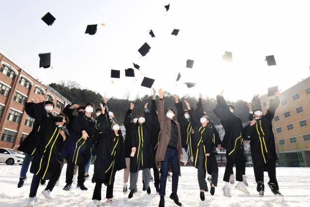 13일 서울 강남구 로봇고등학교에서 졸업을 한 3학년 학생들이 담임선생님과 학사모를 던지고 있다. 사진공동취재단