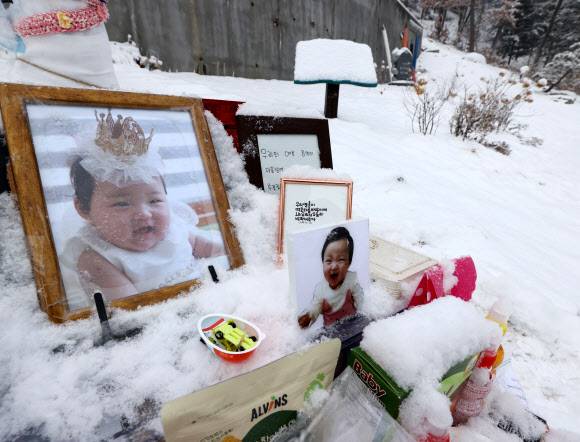 학대로 생후 16개월 만에 숨진 정인이의 양부모에 대한 첫 재판이 열린 13일 정인이가 묻힌 경기도 양평 하이패밀리 안데르센 공원묘원에 정인이를 추모하는 시민들이 두고 간 선물과 메시지 등이 놓여 있다. 연합뉴스