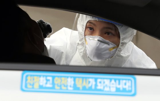 지난 11일 부산 연제구 아시아드주경기장 주차장에 마련된 이동선별검사소에서 의료진이 택시기사의 검체를 채취하고 있다. 송봉근 기자