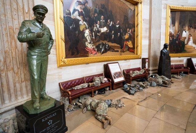 13일(현지시간) 주방위군들이 마스크를 끼고 일정한 거리를 유지한 채 미 국회의사당 대리석에 누워 잠을 청하고 있다. UPI연합뉴스