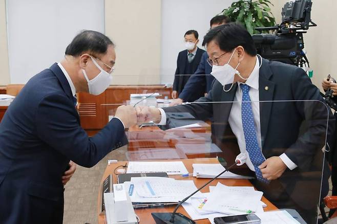 지난해 11월 3일 서울 여의도 국회에서 기획재정위원회 전체회의를 마치고 윤후덕 기획재정위원회 위원장(오른쪽)이 홍남기 부총리 겸 기획재정부 장관(왼쪽)과 주먹인사를 하고 있다. (공동취재사진) /사진= 뉴시스