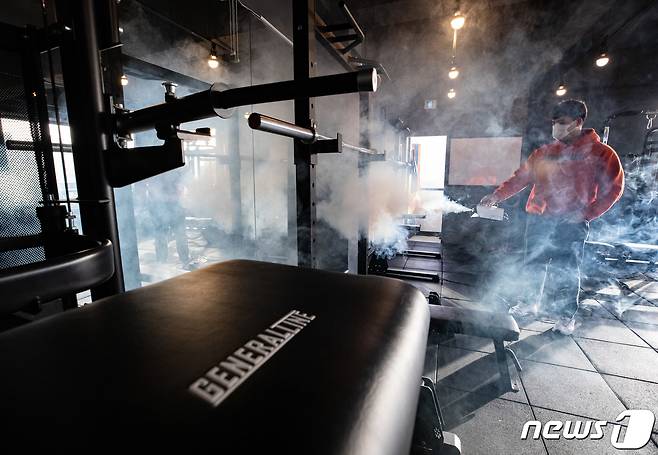 15일 경기도 화성시의 한 헬스장에서 관계자가 신종 코로나바이러스 감염증(코로나19) 방역작업을 하고 있다. 정부는 사회적 거리두기 장기화 및 형평성 논란으로 불거진 헬스장, 코인노래방 등 집합금지 업종 업주들의 영업 허용 의견을 수렴하고 관련 부처 토의를 통해 입장을 정하기로 했다. 2021.1.15/뉴스1 © News1 이재명 기자