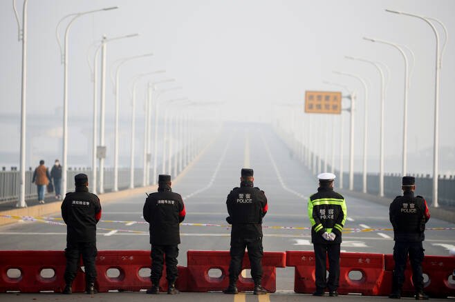 중국 경찰(공안)이 코로나19 확산 차단을 위해 폐쇄된 도로를 통제하고 있다.[로이터]