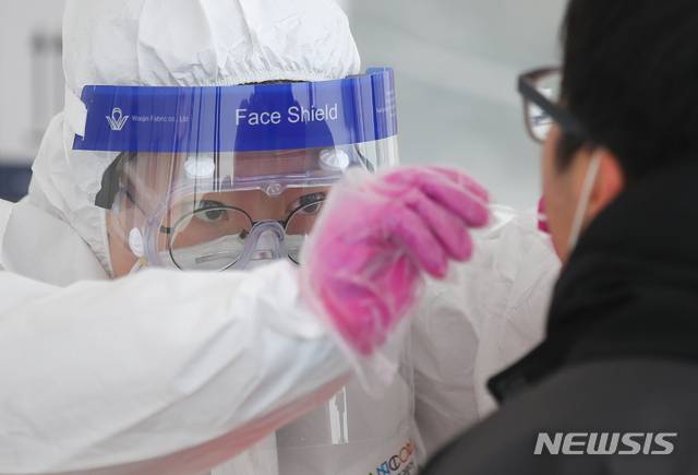 [제주=뉴시스]우장호 기자 = 제주 지역에 강추위 기승을 부리고 있는 7일 제주시보건소 내 주차장 한 켠에 마련된 코로나19 선별진료소에서 의료진들이 검체 채취를 하고 있다. 2021.01.07. woo1223@newsis.com