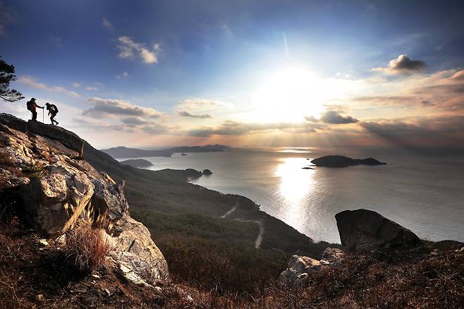 비상하는 새처럼 시원하게 경치가 터지는 비조봉 바위능선. 꼬불꼬불한 덕적도 순환도로 건너 무인도인 흑도가 단정하게 앉아 있다.