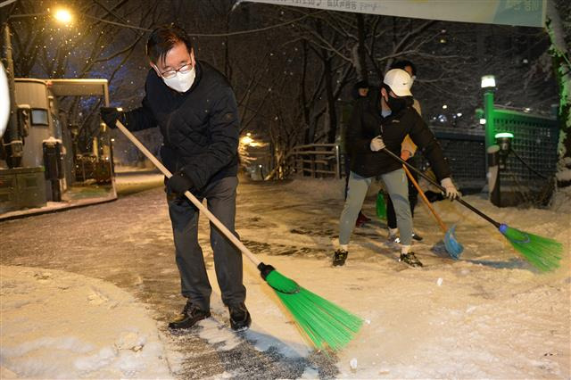 유덕열(왼쪽) 서울 동대문구청장이 지난 12일 오후 직원들과 함께 제설 작업을 하고 있다. 동대문구는 서울시보다 강력한 제설 대책으로 폭설의 피해와 혼란을 최소화했다는 평가를 받고 있다.동대문구 제공