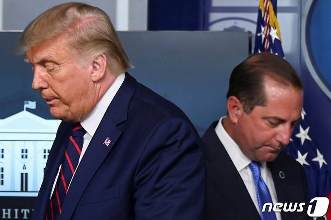 도널드 트럼프 미국 대통령과 앨릭스 에이자 미 보건복지부 장관(오른쪽)© 로이터=뉴스1