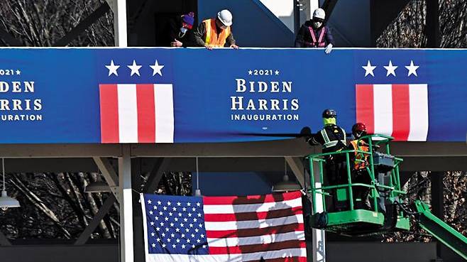 조 바이든 미국 대통령과 카멀라 해리스 부통령 취임을 엿새 앞둔 14일(현지 시각) 워싱턴 백악관 인근에서 취임 당일 행진 동선을 따라 현수막을 설치하고 있다. /로이터 연합뉴스