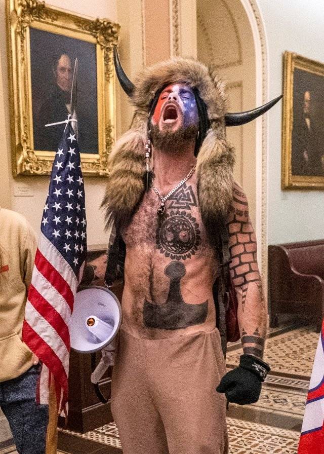 미 극우 음모론단체 큐어논의 핵심 회원인 제이컵 챈슬리가 6일 상의를 탈의한 채 소뿔 모자를 쓰고 워싱턴 국회의사당에 난입해 고함을 지르고 있다. 워싱턴=AP 뉴시스