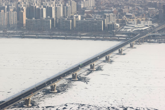 지난 13일 오전 서울 원효대교 인근 결빙된 한강 위로 전날 내린 눈이 쌓여있다. (사진=연합뉴스)