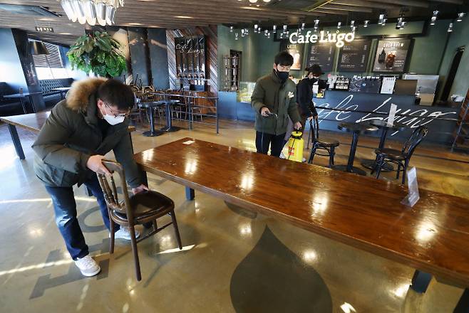 18일부터 카페에서 취식 가능 매장 내 취식 허용을 하루 앞둔 17일 오후 대구 달서구의 한 카페에서 직원들이 방역작업과 함께 치웠던 의자를 테이블마다 다시 놓고 있다.  연합뉴스