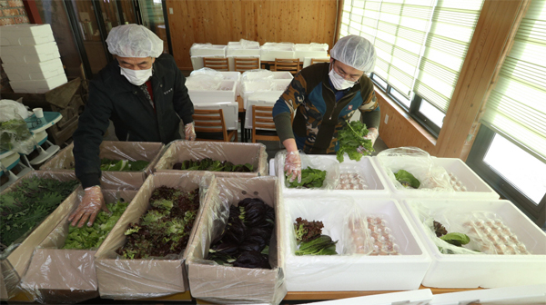 류근모 회장(왼쪽)과 아들이 구독서비스로 보내질 계란과 쌈 채소를 배달 상자에 담고 있다.