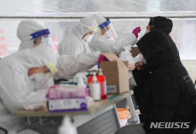 [제주=뉴시스]우장호 기자 = 제주 지역에 강추위 기승을 부리고 있는 7일 제주시보건소 내 주차장 한 켠에 마련된 코로나19 선별진료소에서 의료진들이 검체 채취를 하고 있다. 2021.01.07. woo1223@newsis.com